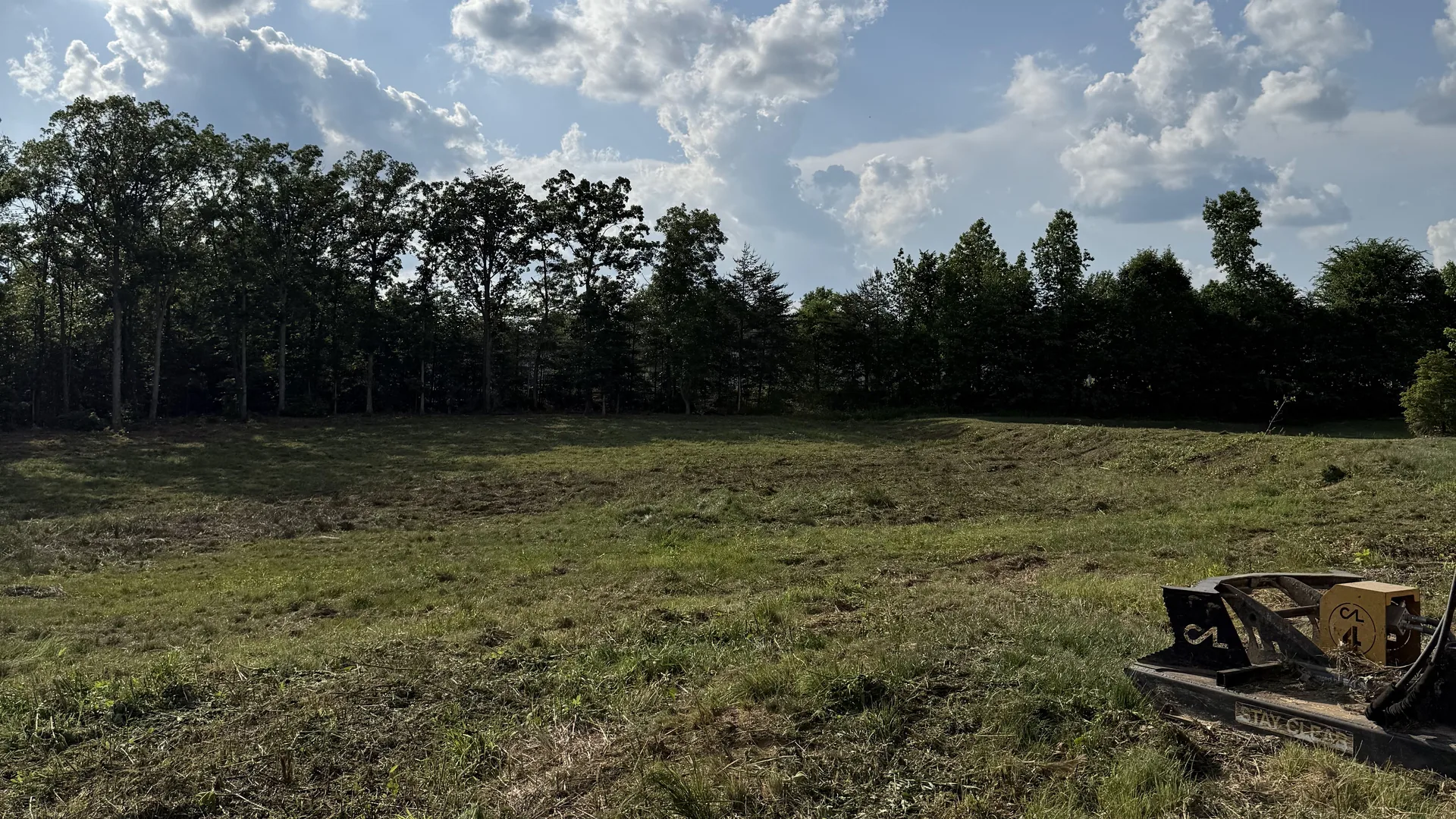 Field cleared with a forestry mulcher, the mulching head sitting on the cut ground